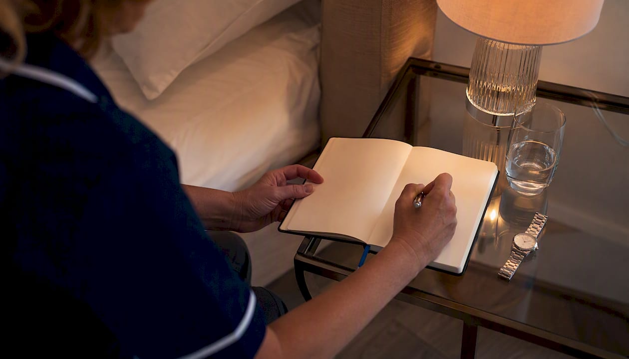 Caregiver hands writing night care records